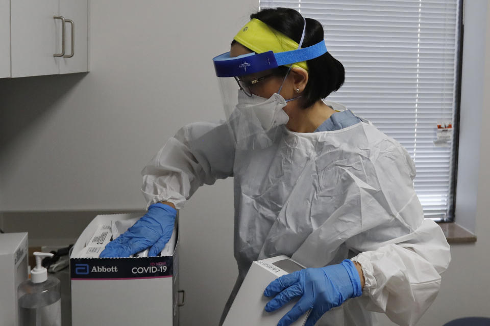 In this Friday, April 24, 2020 photo, Wayne State University medical school student Lucia Luna-Wong checks COVID-19 test kits at a testing center in Detroit. Luna-Wong said she didn't hesitate when offered a chance to join what she calls a "crash course in public health." She wants to specialize in infectious diseases. She's volunteering in one of America's hardest-hit cities, testing police officers, firefighters, bus drivers and other essential workers who keep Detroit running. (AP Photo/Carlos Osorio)