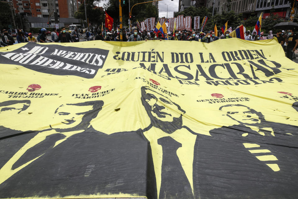 A giant banner that shows images of President Ivan Duque, former President Alvaro Uribe and Gen. Oscar Atehortua, with a message that asks in Spanish: "Who gave the order to massacre young people in Bogota," during an anti-government protest in Bogota, Colombia, Tuesday, July 20, 2021, as the county marks its Independence Day. (AP Photo/Ivan Valencia)