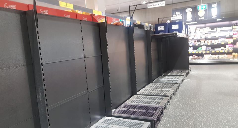 A supermarket shelf emptied of toilet paper.