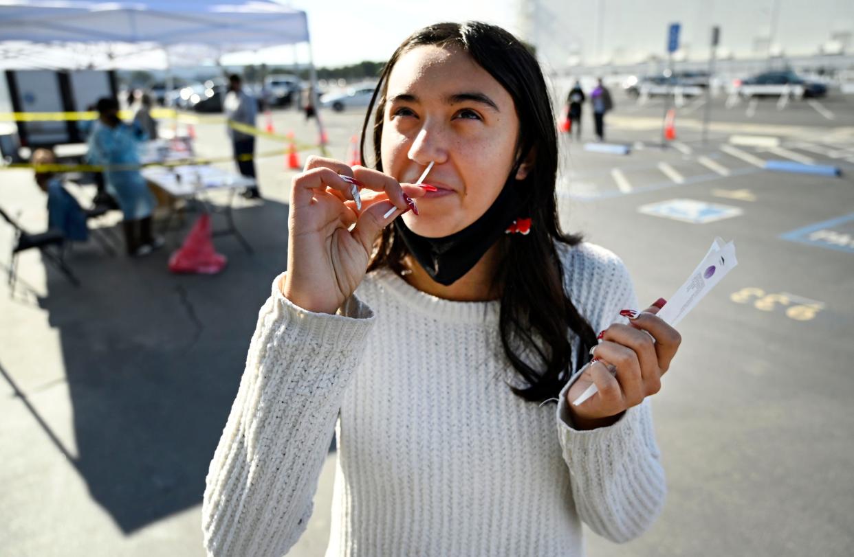 Young person takes nasal COVID-19 test in testing center.