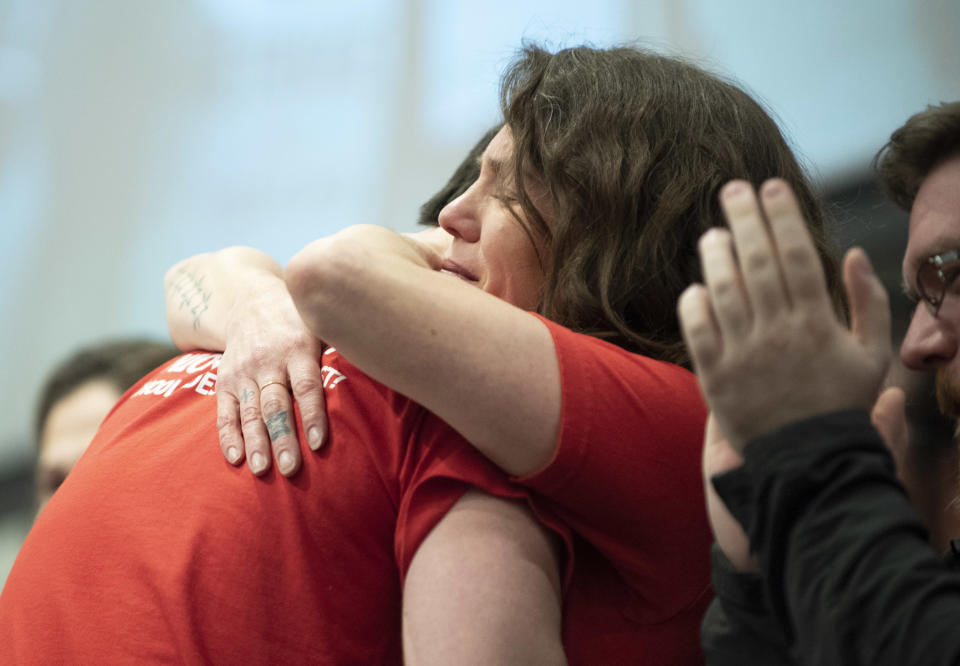 Caroline Rutherford embraces Andy Crooks during a news conference at the Chicago Teachers Union headquarters in Chicago on Sunday, Dec. 9, 2018. The nation's first teachers' strike against a charter school operator will end after their union and management struck a tentative deal Sunday that includes protections for students and immigrant families living in the country illegally. (Colin Boyle/The Beacon-News via AP)