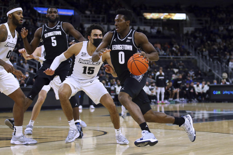 Georgetown's Aminu Mohammed (0) drives to the basket as Providence's Justin Minaya (15) defends during the second half of an NCAA college basketball game Thursday, Jan. 20, 2022, in Providence, R.I. (AP Photo/Stew Milne)