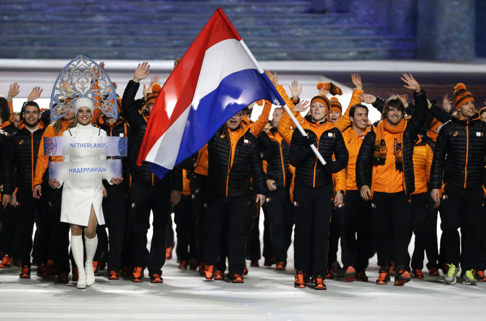 Jorien ter Mors of Netherlands carries the national flag as she arrives during the opening ceremony of the 2014 Winter Olympics in Sochi, Russia, Friday, Feb. 7, 2014. (AP Photo/Mark Humphrey)