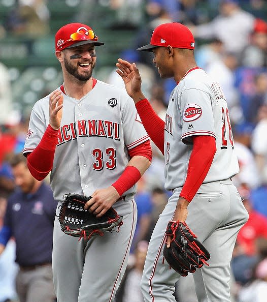 Raisel Iglesias of the Cincinnati Reds is congratulated by Jesse Winker #33 after pitching for a save in the 9th inning against the Chicago Cubs at Wrigley Field on May 24, 2019 in Chicago, Illinois.