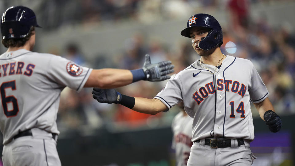 Houston Astros' Mauricio Dubon (14) celebrates with teammate Jake Meyers (6) after scoring on a sacrifice fly during the sixth inning of a baseball game against the Texas Rangers in Arlington, Texas, Friday, June 30, 2023. (AP Photo/LM Otero)