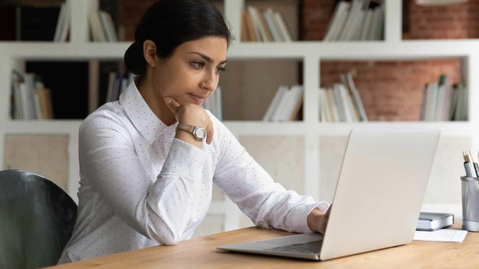 Smart young brown business woman working from home on a laptop