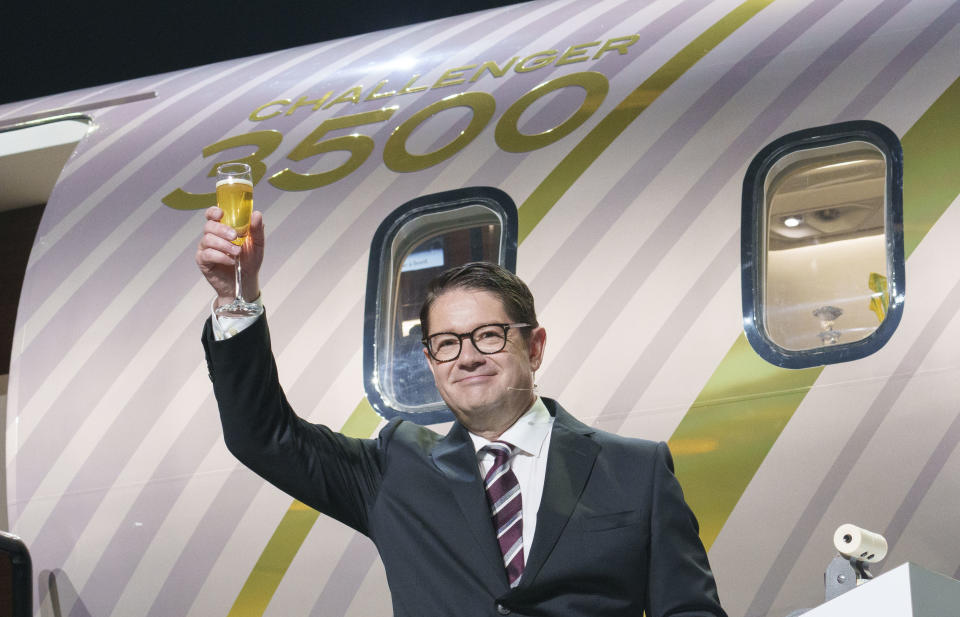 Bombardier president and CEO Eric Martel raises his glass in front of a scale model of the new Challenger 3500 in Montreal on Tuesday, September 14, 2021. THE CANADIAN PRESS/Paul Chiasson