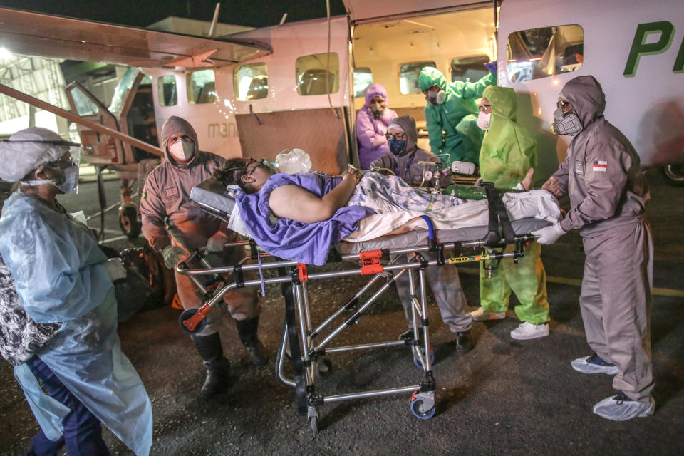 MANAUS, BRAZIL - MAY 25: Nurses and doctors rescue a woman in critical conditions after being infected by coronavirus (COVID-19) from the airplane that took her from Parintins city to Manaus on May 25 2020 in Manaus, Brazil. Intensive Care Unit flights have been made daily to remote areas in Amazonas to rescue for patients seriously infected by coronavirus and bring them to Manaus, where the medical structure is bigger and more efficient. (Photo by Andre Coelho/Getty Images)