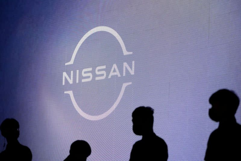 FILE PHOTO: People stand near the Nissan logo during a media day for the Auto Shanghai show