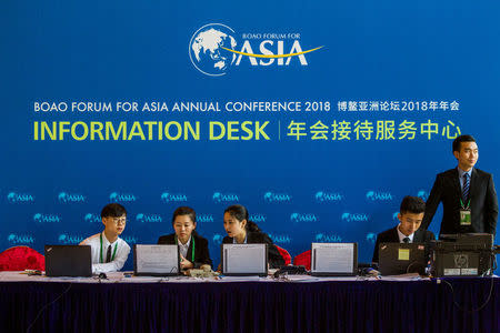 Staff members are seen at the information desk at the Boao Forum in Qionghai, Hainan province, China, April 8, 2018. Picture taken April 8, 2018. REUTERS/Stringer