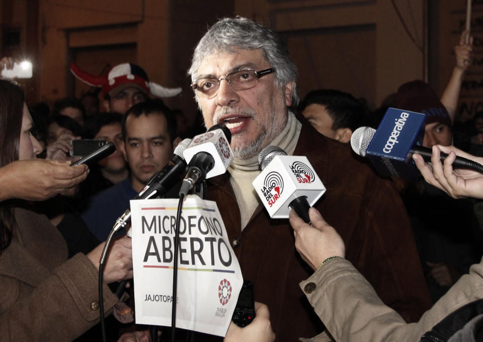 Paraguay's former President Fernando Lugo talks through the “open microphone” of the Public Television, surrounded by reporters and followers in downtown Asuncion, Paraguay, in the early hours of Sunday, June 24, 2012. Lugo spoke in a pre-dawn special televised "open microphone" program hosted by the state-funded Public Television channel that was created by his government, to denounce his ouster as a "parliamentary coup". (AP Photo)