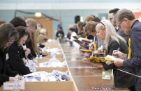 Party observers record votes as ballot boxes are opened at The Leisuredrome in Bishopbriggs for the East Dunbartonshire Parliamentary general election count, Thursday Dec. 12, 2019. (Jane Barlow/PA via AP)