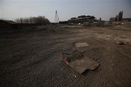 A piece of metal from a deserted vehicle is seen on the ground inside an abandoned steel mill of Qingquan Steel Group in Qianying township, Hebei province February 18, 2014. REUTERS/Petar Kujundzic