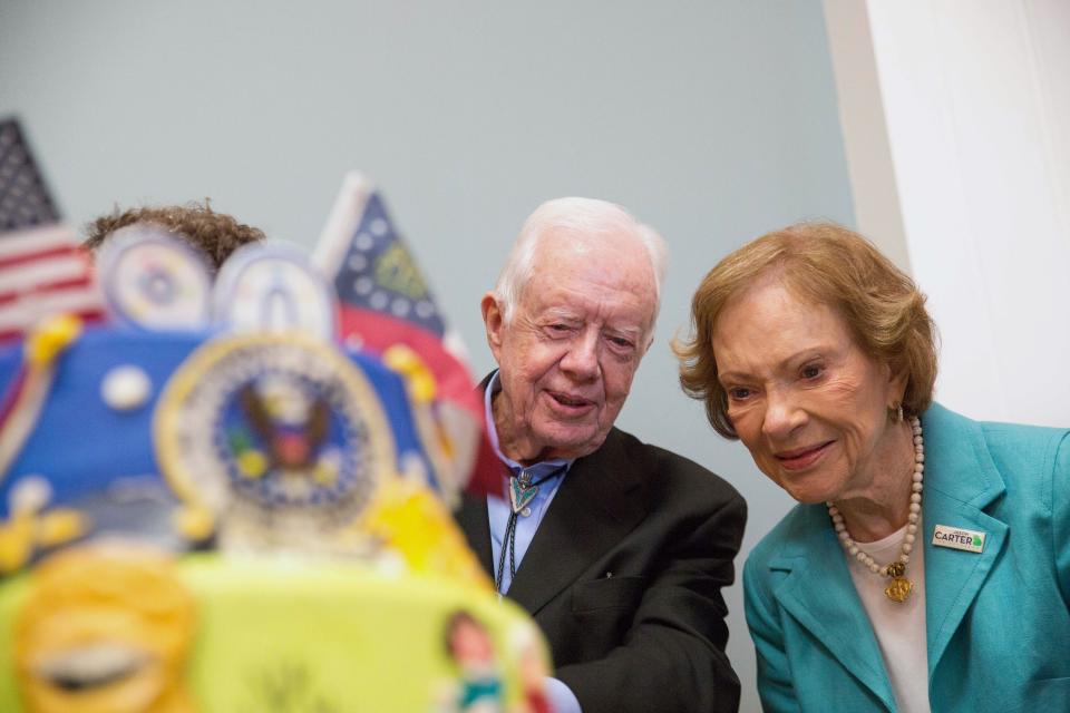 FILE - In this Saturday, Oct. 4, 2014, file photo, former President Jimmy Carter, left, and former first lady Rosalynn Carter look at a birthday cake during Jimmy Carter's 90th birthday celebration held at Georgia Southwestern University, in Americus, Ga. Carter, the oldest former U.S. chief executive ever, will quietly mark his 97th birthday at home in southwest Georgia on Friday, Oct. 1, 2021, an aide said. (AP Photo/Branden Camp, File)