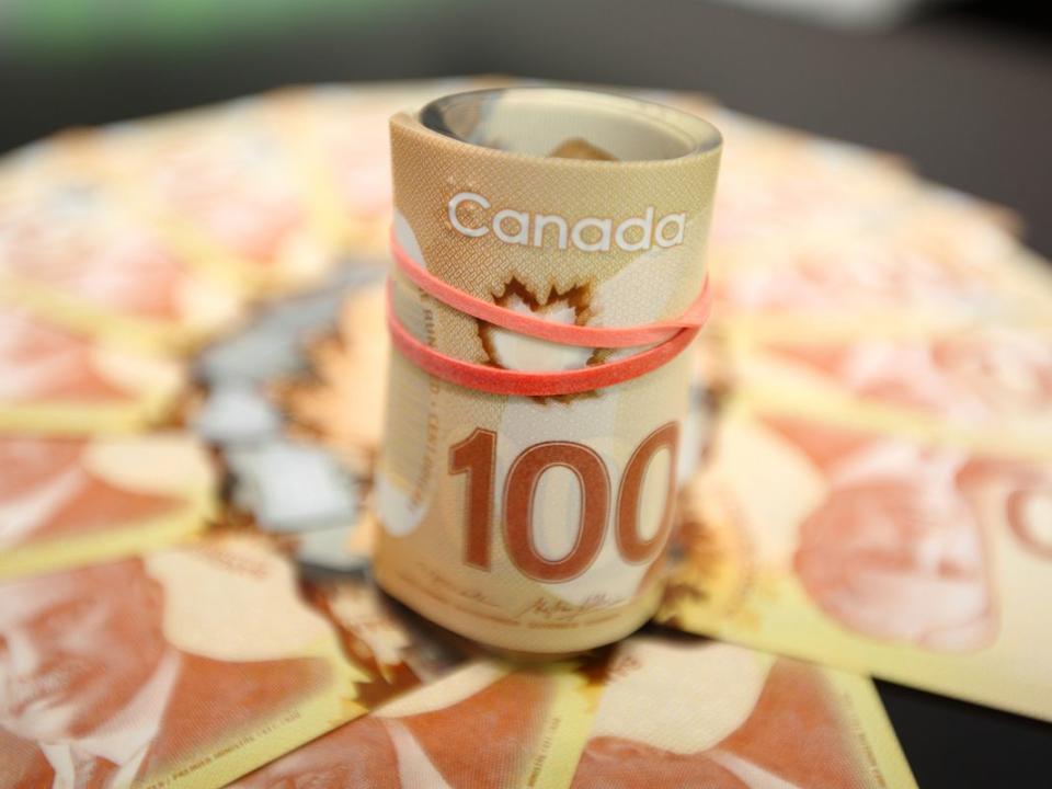 Canadian fanned hundred dollar bills and roll of bills