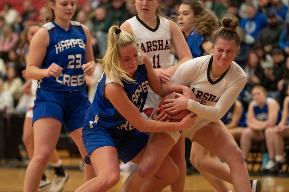 Harper Creek senior Payton Rice and Marshall junior Alexis Stealy struggle for the ball during a game at Marshall High School on Friday, Jan. 27, 2023.