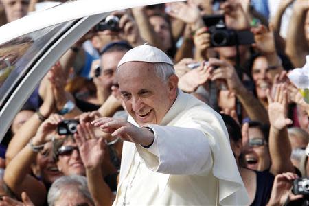 Pope Francis waves as he arrives to lead a mass outside the Shrine of Our Lady of Bonaria in Cagliari September 22, 2013. REUTERS/Giampiero Sposito