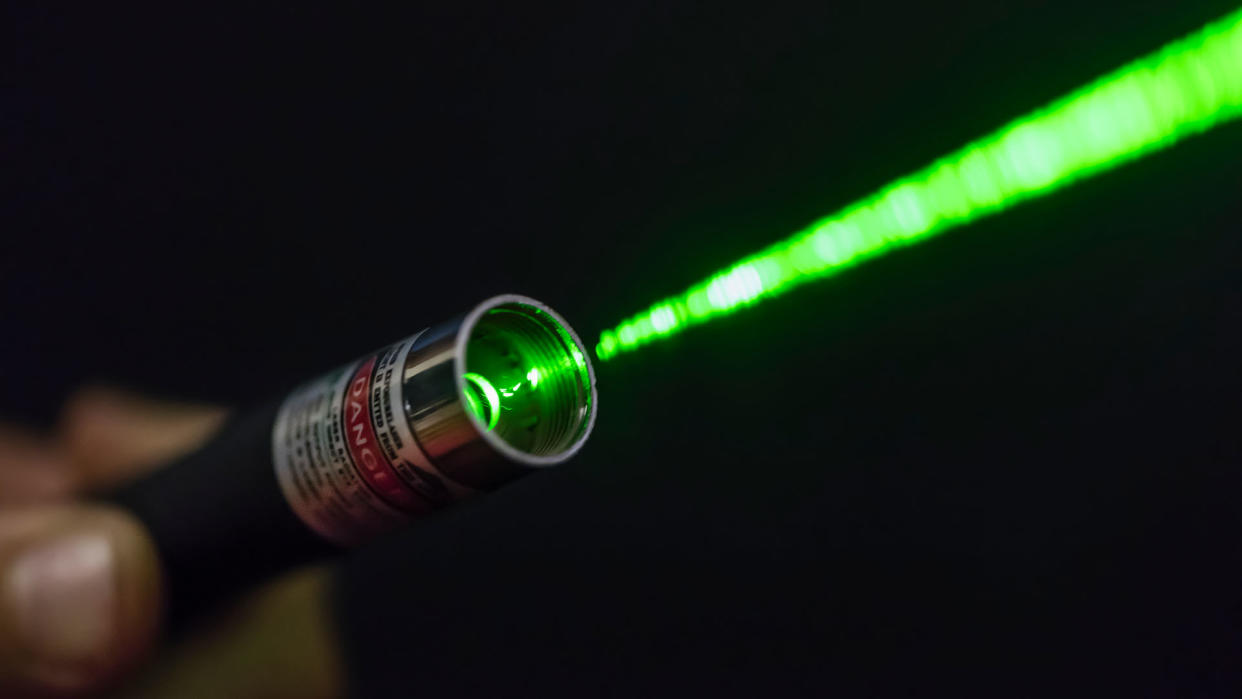  Green laser beam coming from a hand-held laser pointer. 