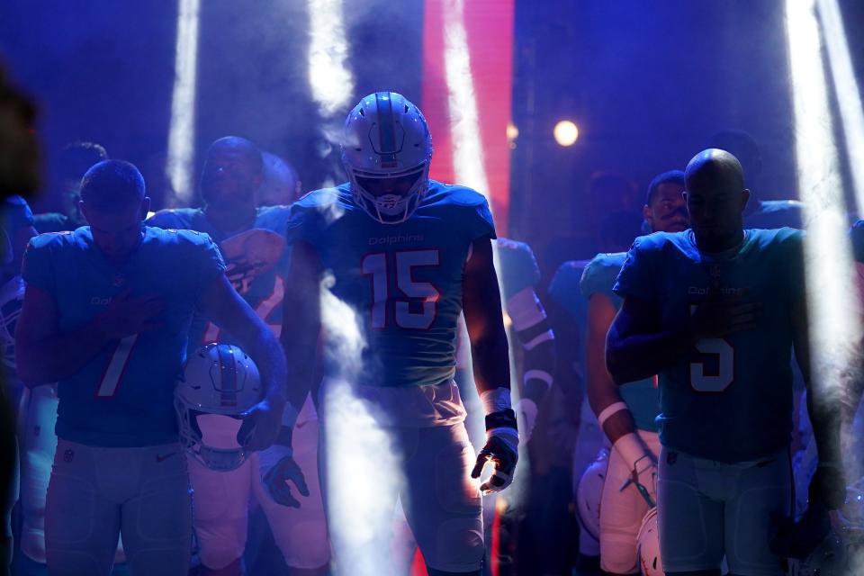 Aug 21, 2021; Miami Gardens, Florida, USA; Miami Dolphins linebacker Jaelan Phillips (15) stands with teammates in the tunnel during the national anthem prior to the game against the Atlanta Falcons at Hard Rock Stadium. Mandatory Credit: Jasen Vinlove-USA TODAY Sports