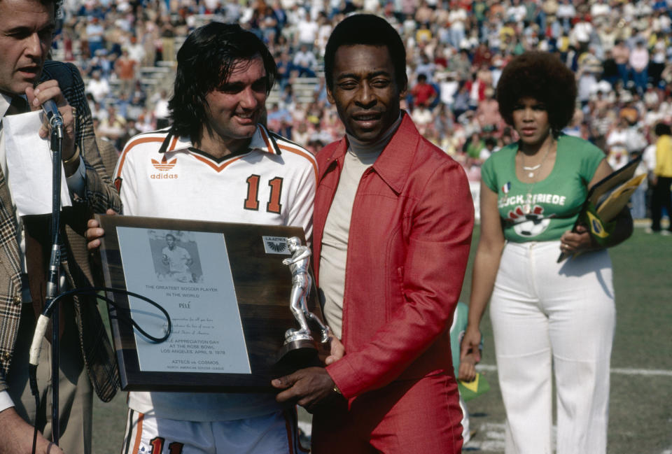 George Best presents Pele with a plaque commemorating the Brazilian as the best soccer player in the world during Pele Appreciation Day at Rose Bowl stadium in Pasedena, California, 9th April 1978