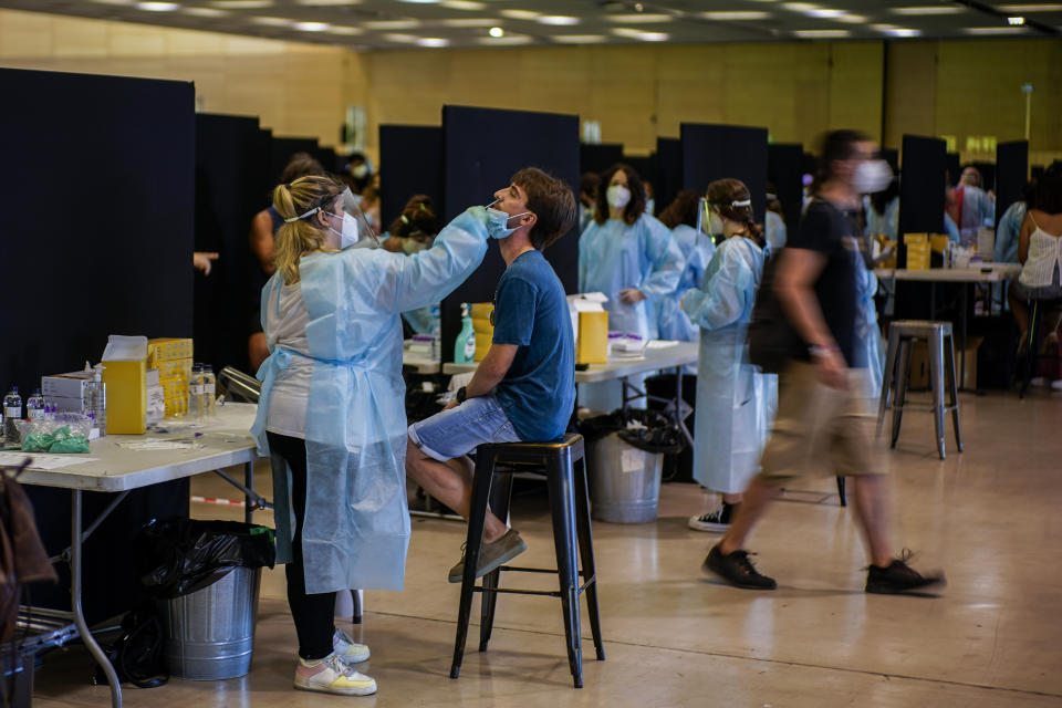 A health worker takes a swab sample collection for a COVID-19 Antigen test ahead of the Cruilla music festival in Barcelona, Spain, Friday, July 9, 2021. (AP Photo/Joan Mateu)