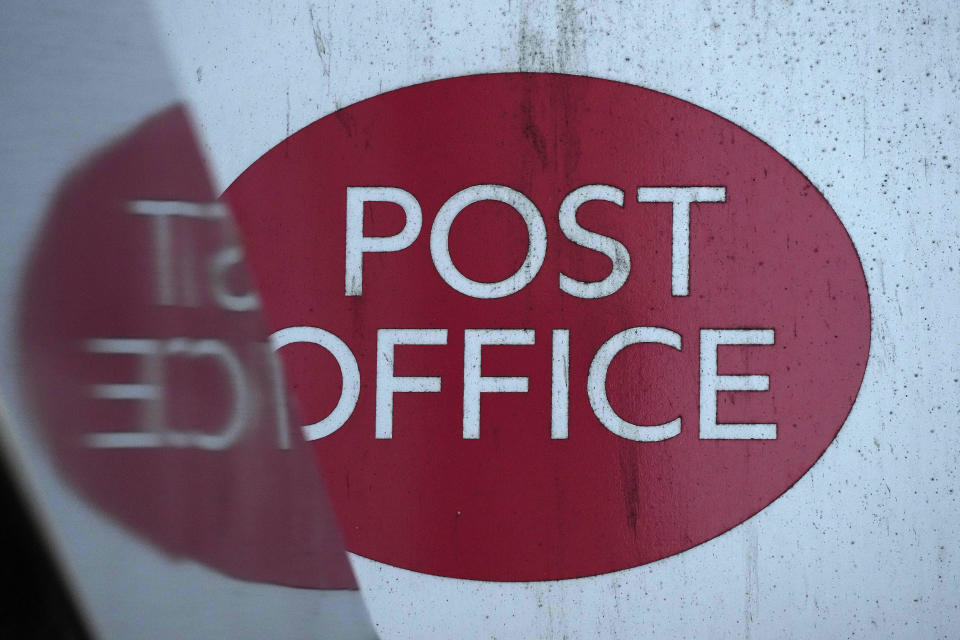 A post office logo on a shop front on a street in London, Tuesday, Jan. 16, 2024. Lawmakers trying to get to the bottom of one of Britain's gravest injustices are questioning bosses of the Post Office and Fujitsu as momentum grew to compensate and clear the names of more than 900 Post Office branch managers wrongly convicted of theft or fraud because of the Japanese company's faulty computer system. (AP Photo/Frank Augstein)