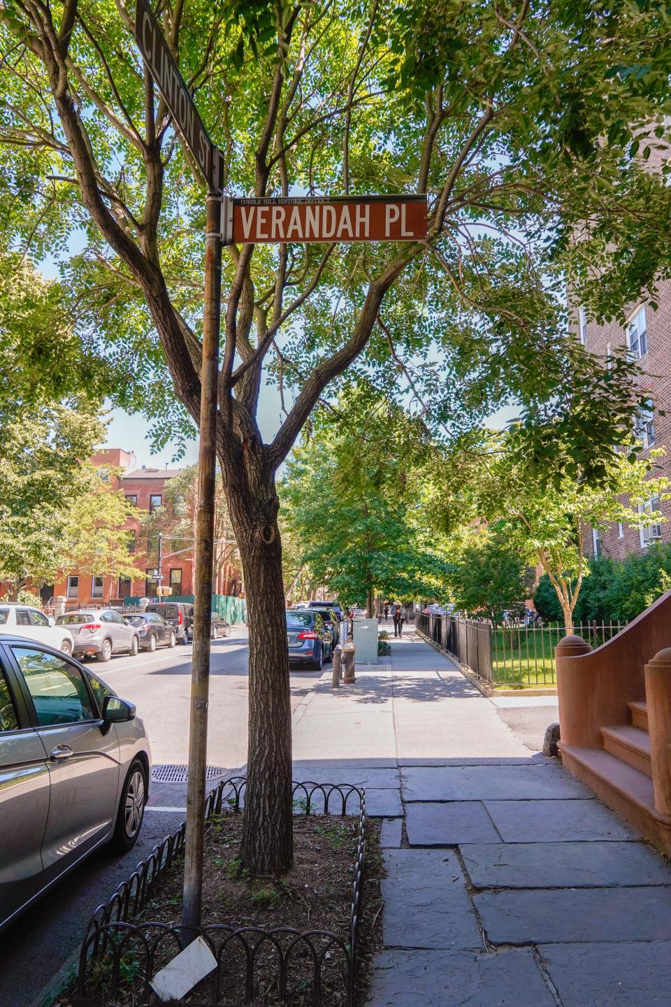 Verandah place sign in front of a tree on a sidewalk