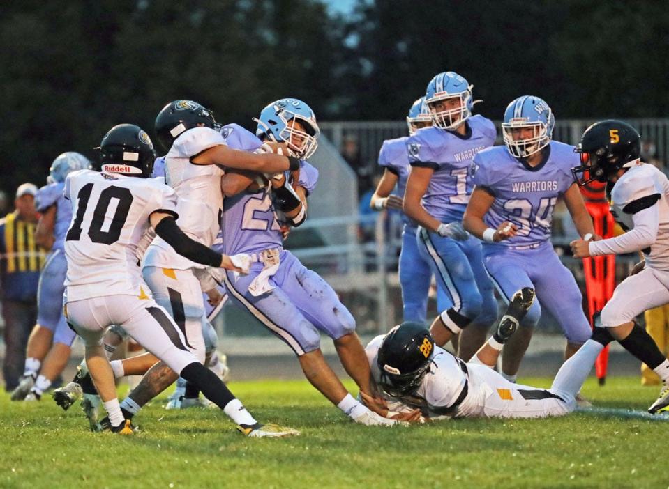 New London’s Dom Lopez and Michael Raines (26) stop the run of WACO’s Simeon Reichenbach in their game at WACO.