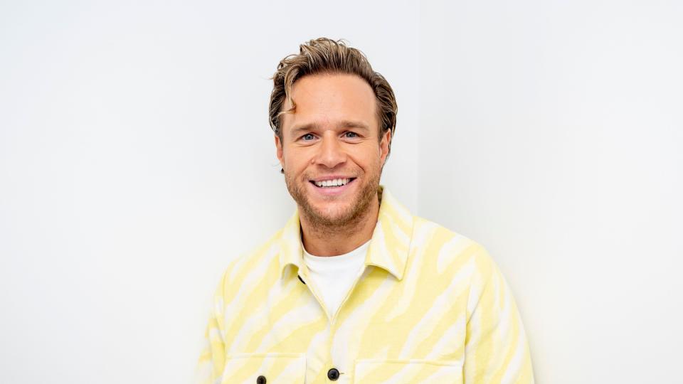 Olly Murs smiling and wearing a yellow and white outfit