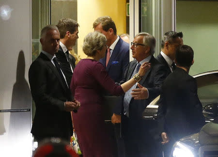 Britain’s Prime Minister Theresa May is greeted by European Commission President Jean-Claude Juncker while leaving the European Commission headquarters after a meeting in Brussels, Belgium October 16, 2017.