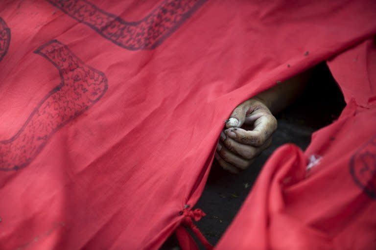 A picture shows the hand of a protester killed during a crackdown by Thai soldiers on the Red Shirt anti-government protesters' camp in Bangkok on May 19, 2010. Thai protest leaders surrendered and told thousands of Red Shirt supporters to end their weeks-long rally after an army assault on their fortified encampment left at least five people dead. AFP PHOTO/PEDRO UGARTE