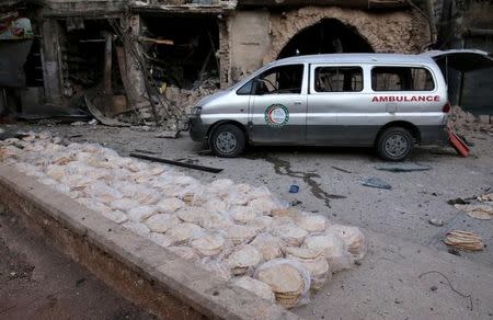 An ambulance is parked next to stacks of bread at a damaged site after an airstrike in the rebel-held Bab al-Maqam neighbourhood of Aleppo, Syria, September 28, 2016. REUTERS/Abdalrhman Ismail