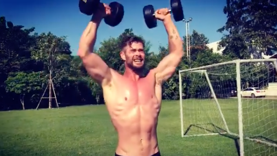 A photo of Chris Hemsworth shirtless lifting weights.