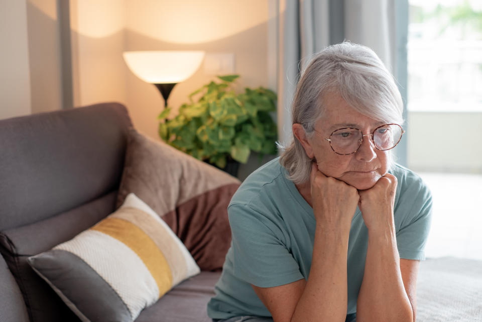 Mujer mayor triste y deprimida sentada sola en casa, mujer mayor que sufre de problemas económicos o de salud, mala relación, sintiéndose sola y deprimida.