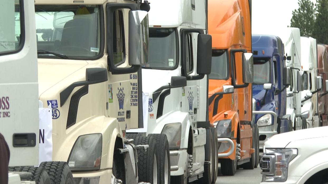 More than 100 port truck drivers and owners participated in a rolling convoy protest from Delta to Vancouver on Sunday in protest of new licensing requirements on drayage businesses. (CBC News - image credit)