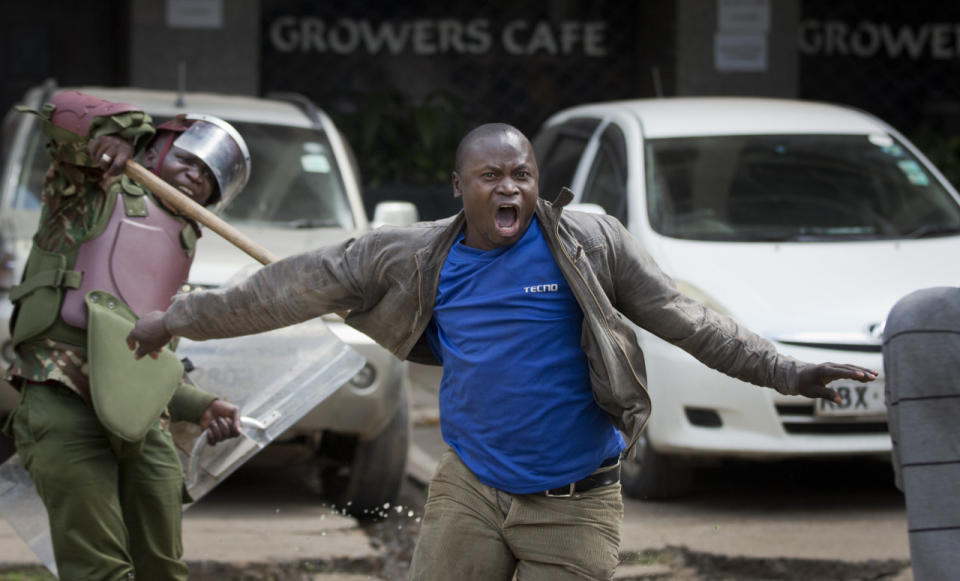 An opposition supporter yells as he is beaten with a wooden club by riot police while trying to flee during a protest in downtown Nairobi, Kenya, May 16, 2016. Kenyan police have tear-gassed and beaten opposition supporters during a protest demanding the disbandment of the electoral authority over alleged bias and corruption. (AP Photo/Ben Curtis)