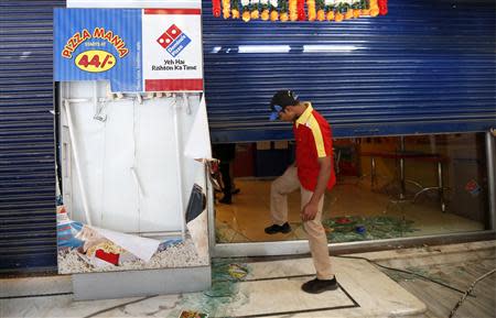 An employee enters the Dominos Pizza outlet after it was ransacked by the activists of Republican Party of India (RPI) in a Mumbai suburb December 20, 2013. REUTERS/Mansi Thapliyal