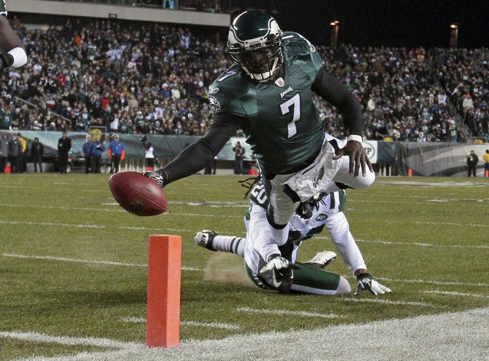 FILE - In a Dec. 18, 2011 file photo, Philadelphia Eagles quarterback Michael Vick (7) scores a touchdown in the first half of an NFL football game, in Philadelphia. The New York Jets signed quarterback Michael Vick and released Mark Sanchez on Friday, March 21, 2014. Vick was a free agent after spending the last five seasons with the Phialdelphia Eagles. (AP Photo/Matt Slocum, File)