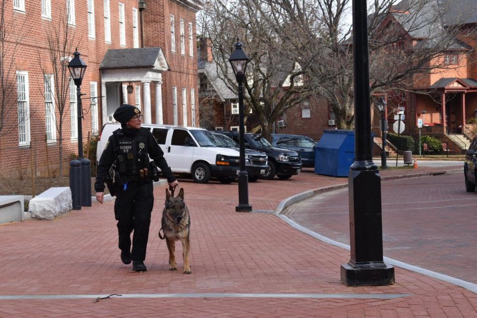 A deputy and K-9 walk near the Maryland Capitol in Annapolis, Md., on Sunday, Jan. 17, 2021. At noon ET, few people were present beyond law enforcement and members of the media.