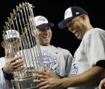 FILE - In this Nov. 4 ,2009, file photo, New York Yankees' Derek Jeter, left, and Mariano Rivera look at the championship trophy after winning the Major League Baseball World Series against the Philadelphia Phillies, in New York. Rivera will be inducted into the Baseball Hall of Fame on Sunday, July 21, 2019. (AP Photo/David J. Phillip, File)