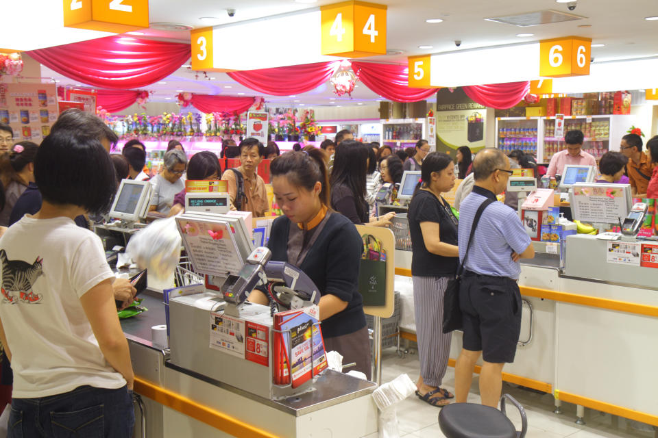 Image showing cashiers dressed in orange and black uniform at the FairPrice Finest at Junction 8.