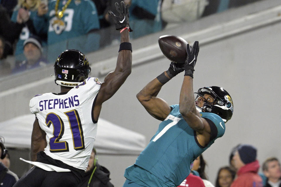 Jacksonville Jaguars wide receiver Zay Jones (7) catches a pass beyond the reach of Baltimore Ravens cornerback Brandon Stephens (21) in the first half of an NFL football game Sunday, Dec. 17, 2023, in Jacksonville, Fla. (AP Photo/Phelan M. Ebenhack)