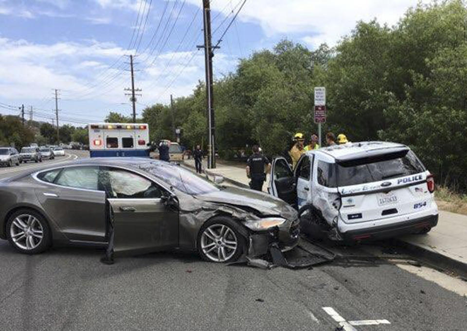 This photo provided by the Laguna Beach Police Department shows a Tesla sedan, left, in autopilot mode that crashed into a parked police cruiser Tuesday, May 29, 2018, in Laguna Beach, Calif. Police Sgt. Jim Cota says the officer was not in the cruiser at the time of the crash and that the Tesla driver suffered minor injuries. (Laguna Beach Police Department via AP)