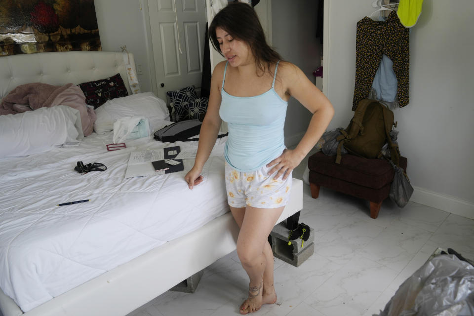 Tatiana Lizarazo Rodriguez takes a break from cleaning the flooded room she shares with her newlywed husband, Friday, April 14, 2023, in Fort Lauderdale, Fla. South Florida has begun draining streets and otherwise cleaning up after an unprecedented storm that dumped upward of 2 feet of rain in a matter of hours. (AP Photo/Marta Lavandier)