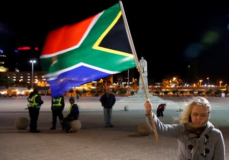 FILE PHOTO: Girl holds a South African national flag as people mourn the death of former President Nelson Mandela outside Cape Town City Hall