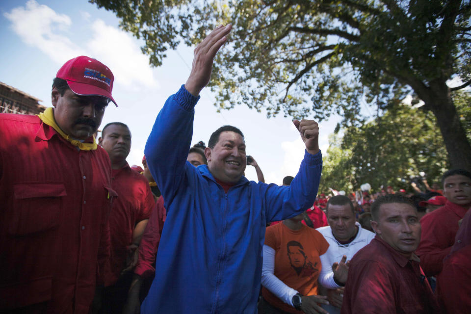 Venezuela's President Hugo Chavez waves to supporters during a stop of a campaign caravan in Sabaneta, Venezuela, Monday, Oct. 1, 2012. Venezuela's presidential election is scheduled for Oct. 7. At left Venezuela's Foreign Affairs Minister Nicolas Maduro.(AP Photo/Rodrigo Abd)