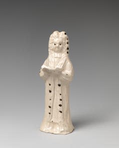 A white porcelain figure against a grey background.