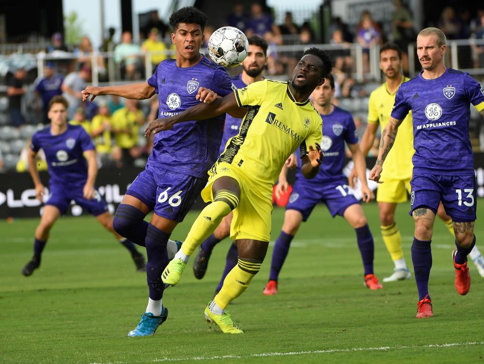 May 25, 2022; Louisville, Kentucky, USA;  Louisville City FC forward Josh Wynder (66) and Nashville SC midfielder Anibal Godoy (20) fight for the ball during the first half at Lynn Family Stadium. Mandatory Credit: Steve Roberts-USA TODAY Sports