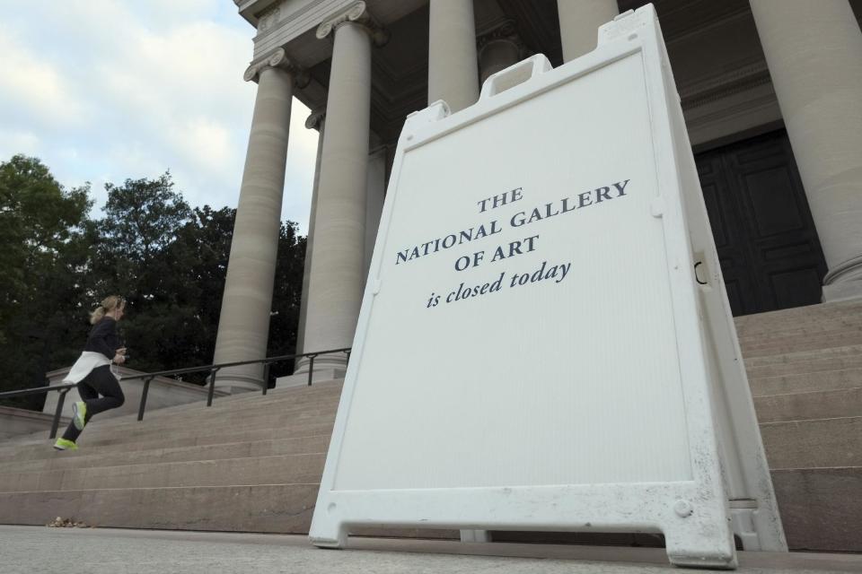 A jogger takes advantage of the empty steps at the Smithsonian's National Gallery of Art in Washington, Tuesday, Oct. 1, 2013, past a sign saying the museum is closed. All of the Smithsonian museums are closed as a result of a budget impasse on Capitol Hill that has shut down many part of the government. (AP Photo/J. David Ake)