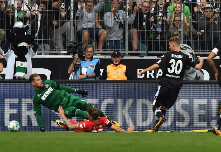 Moenchengladbach's defender Nico Elvedi (R) scores against Cologne on August 20, 2017